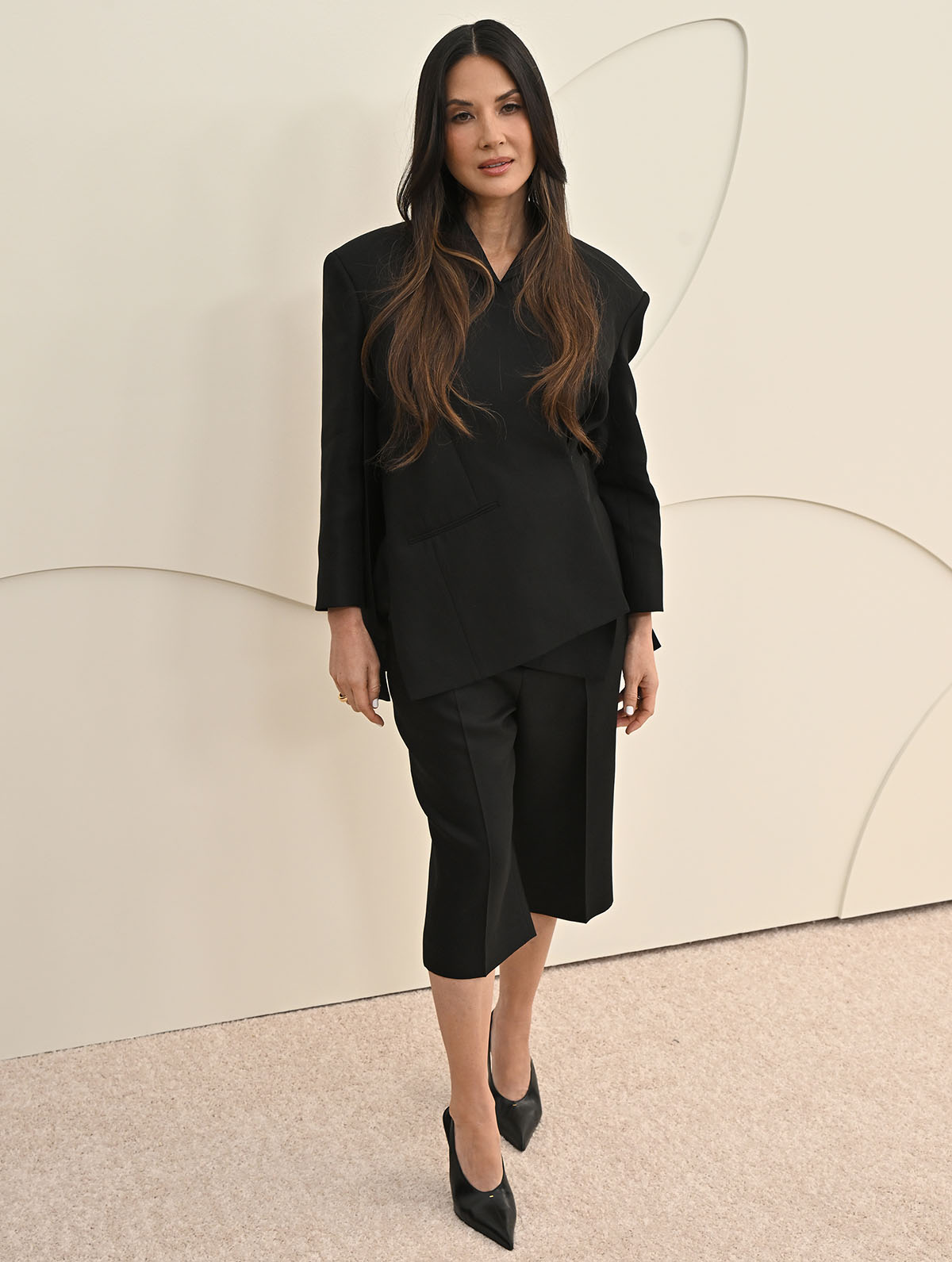 Olivia Munn teams her glove pumps with knee-length pleated pants and a wrap-style blazer