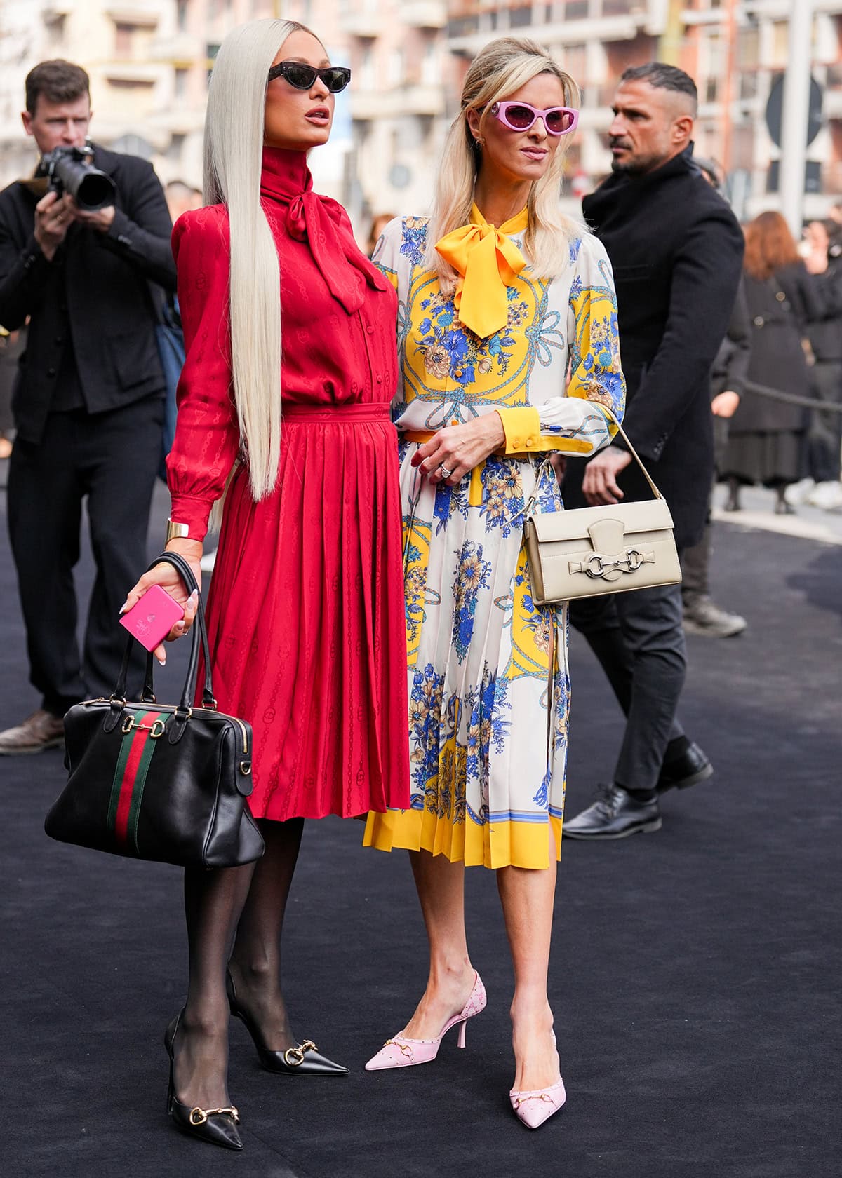 Nicky Hilton pairs her girly Gucci pumps with a Mediterranean-inspired dress in yellow, white, and blue, featuring a lavalliere tie and a pleated midi skirt
