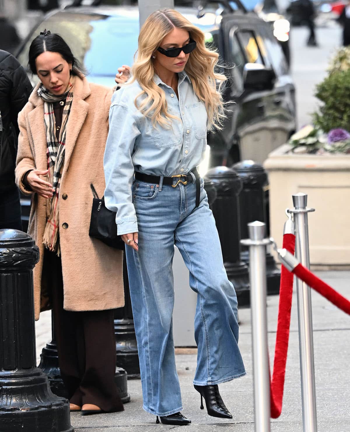 Sydney Sweeney steps out in a double-denim look, wearing the men's AE Everyday Denim Shirt with the AE Dreamy Drape Super High-Waisted Baggy Wide-Leg Jeans and a black AE77 Leather Hook Belt