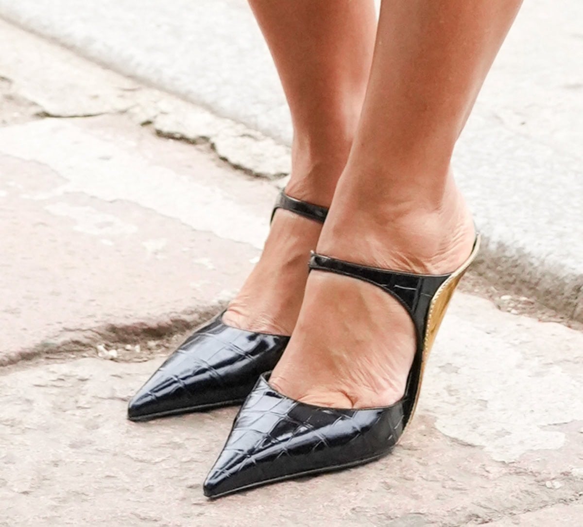 Tracee Ellis Ross steps out in glossy black croc-embossed Mary Jane mules, defined by sharp pointed toes and subtle gold-trimmed heels