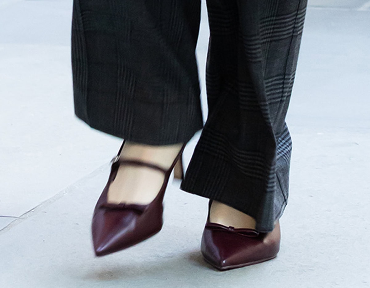 Anna Cathcart wears the burgundy Charles Keith “Sonali” pumps featuring a bow at the vamp, pointed toes, a strap across the foot, and a slingback strap