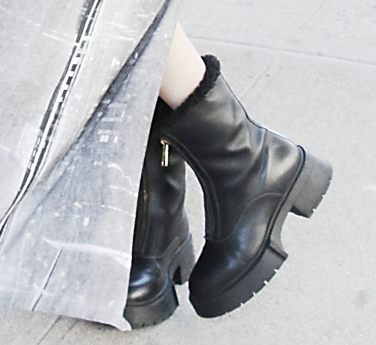 Chloe East adds edge to her look with the Coach “Leah” boots featuring a zipped front and genuine black shearling-lined collar