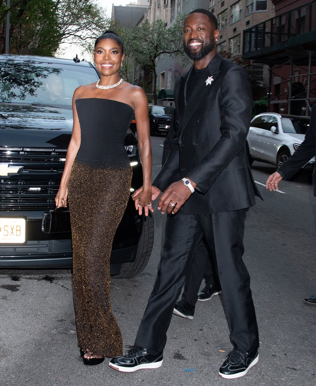 Gabrielle Union, with her husband Dwayne Wade, keeps it simple in a Salih Balta dress, featuring a black strapless bodice and a glittery gold beaded column skirt, finished with a Tiffany Co. turtle-shell motif necklace