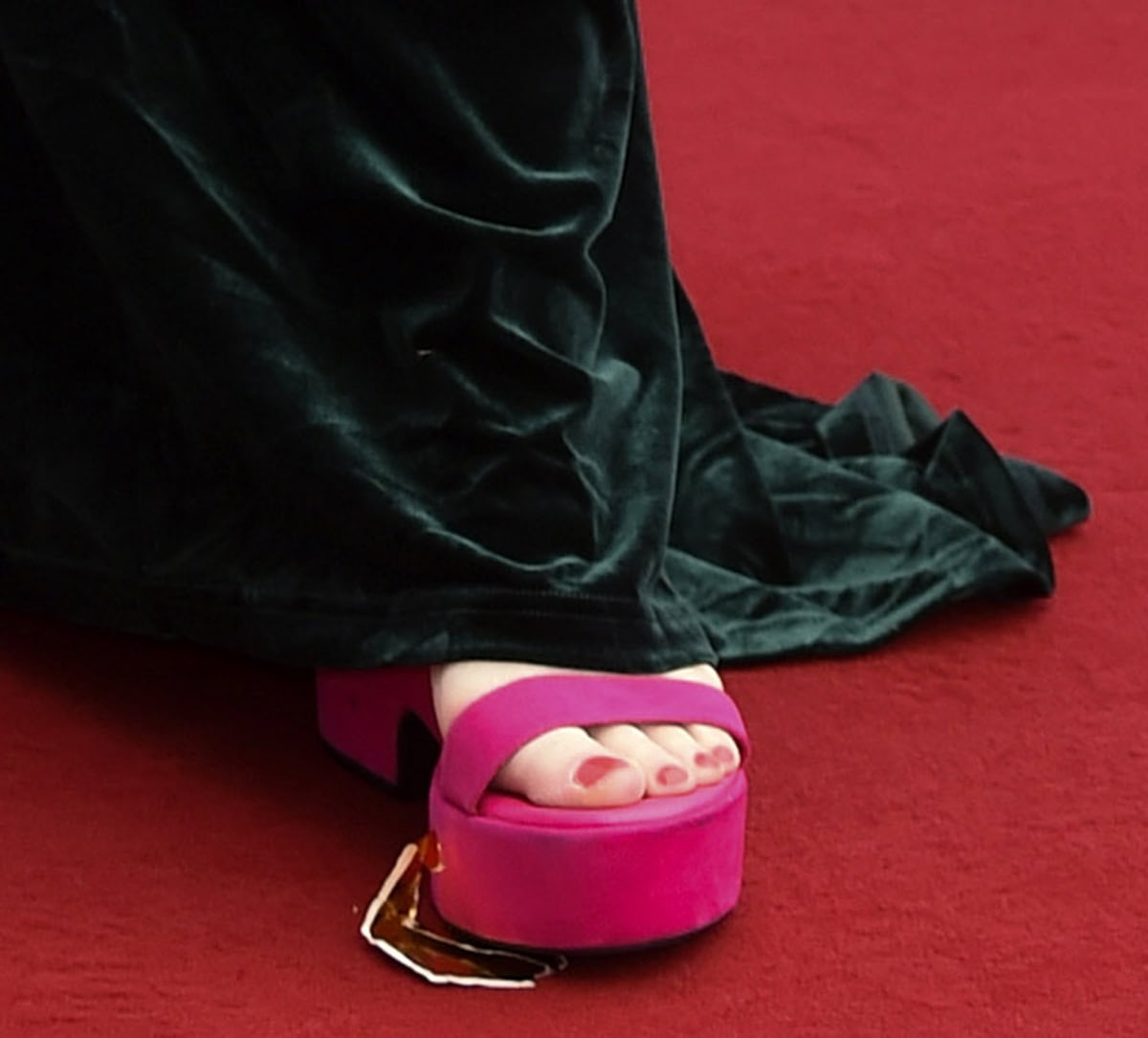 Amy Gledhill commands attention in her bright pink suede sandals with open toes, showcasing her pink pedicure, thick platforms, and comfy block heels
