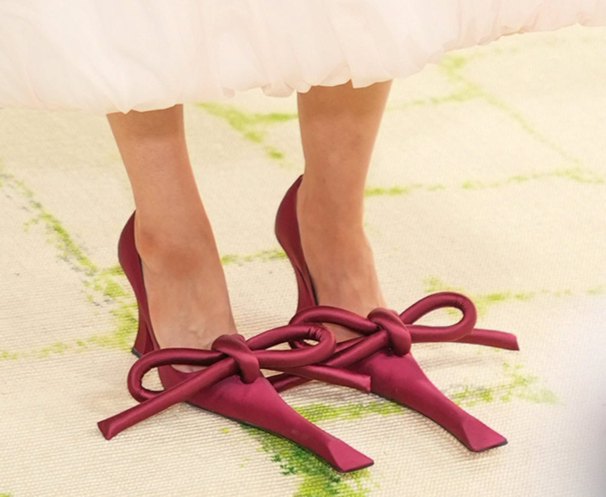 Anna Weyant opts for the whimsical burgundy satin Marc Jacobs pumps with elongated duckbill toes, oversized bows, and curved heels