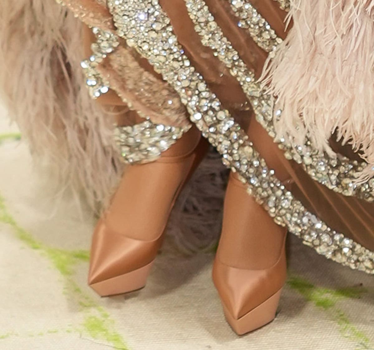 Beyonce keeps her footwear simple with the nude Amina Muaddi “Yigit” pumps featuring sharp pointed platforms, slim ankle straps, and high heels
