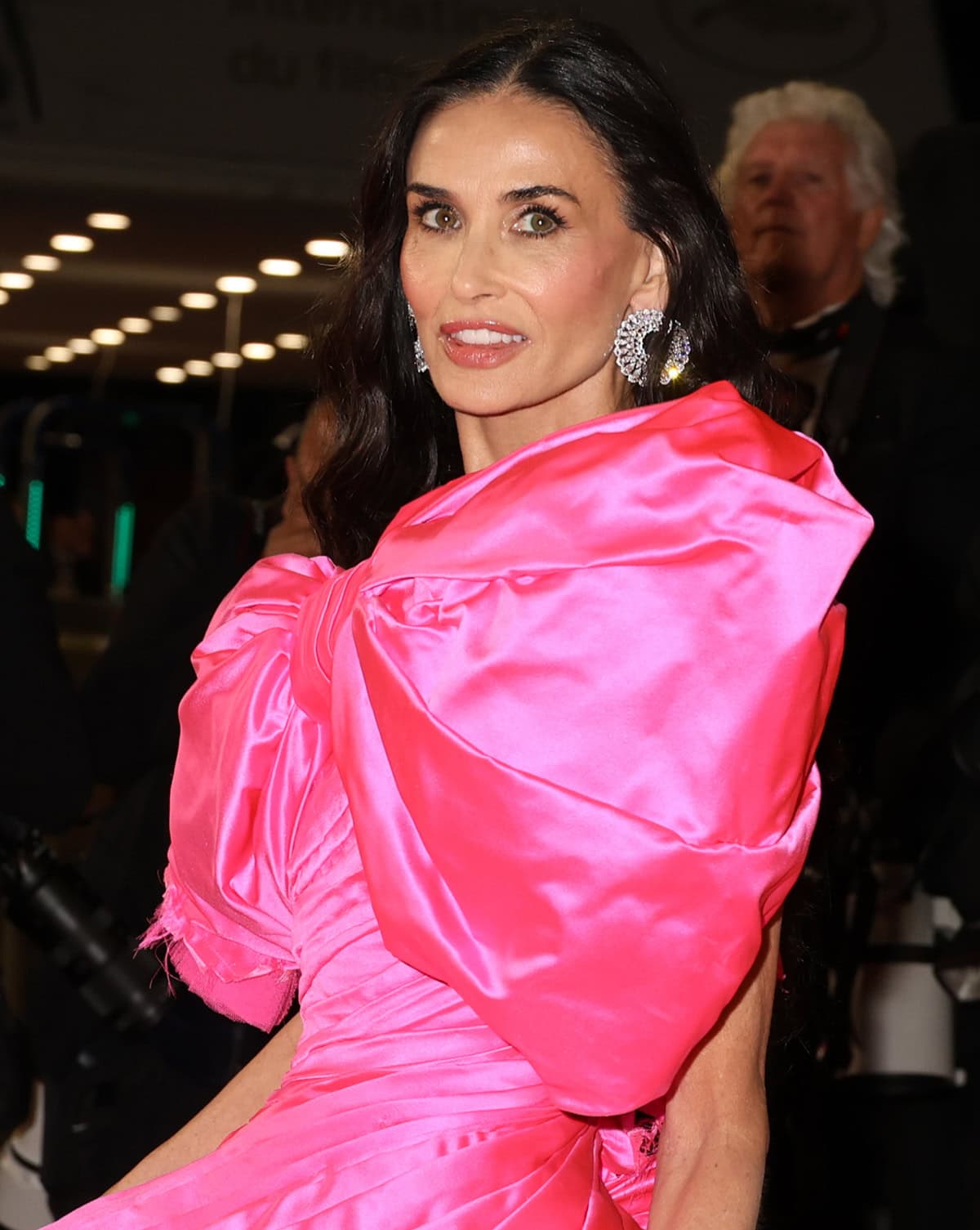 Demi Moore styles her all-pink Matières Fécales look with wavy hair and statement Chopard earrings