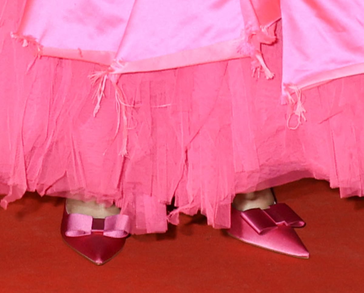 Demi Moore slips into a pair of hot pink pointy pumps with a structured bow from the Matières Fécales x Christian Louboutin The One Percent Fall/Winter 2025 collection