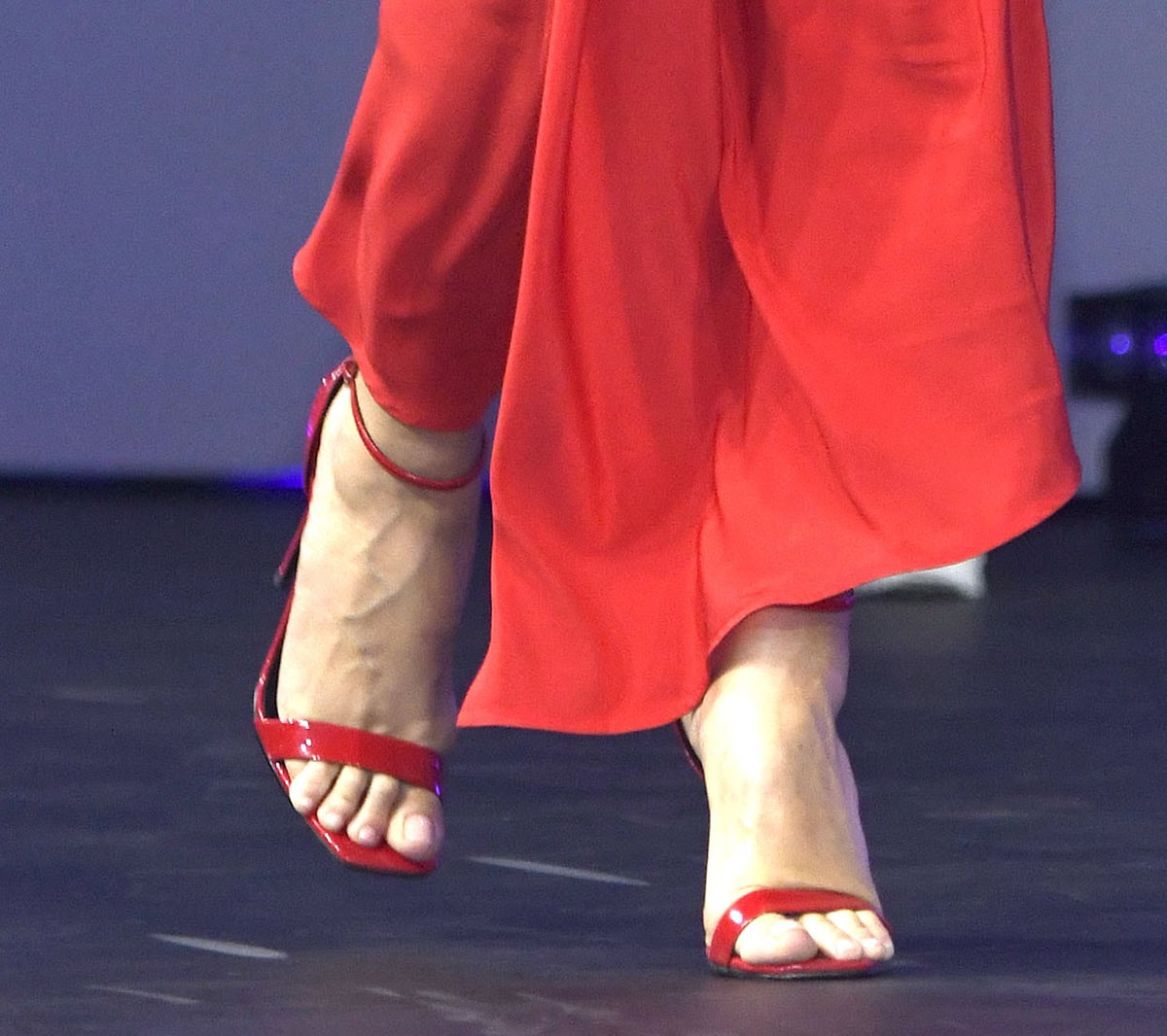 Heidi Klum slips into a pair of shiny red Femme LA "Amiri" sandals featuring open square toes, a slim ankle strap, and towering stiletto heels