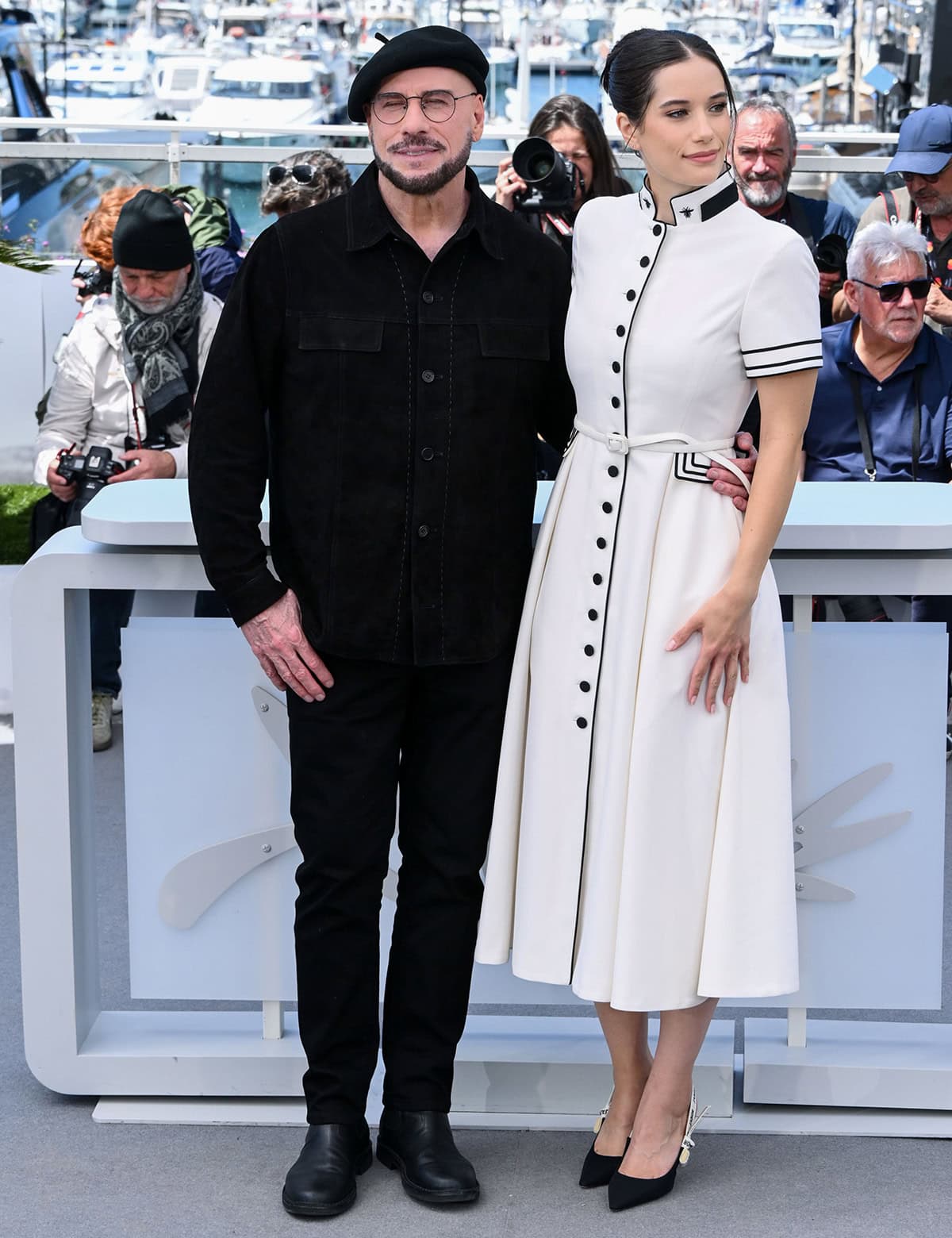 John Travolta and his daughter, Ella Bleu Travolta, attend the Cannes Film Festival photocall of Propeller One-Way Night Coach in a Parisian chic all-black look with a beret and a black-and-white Dior dress and pumps, respectively