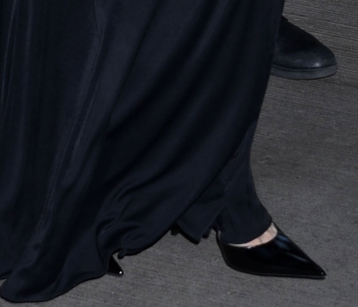 Angelina Jolie's sharply pointed black patent pumps peek out from beneath her sweeping Tom Ford gown, their sleek silhouette and slender stiletto heels subtly elongating the line of her monochromatic look