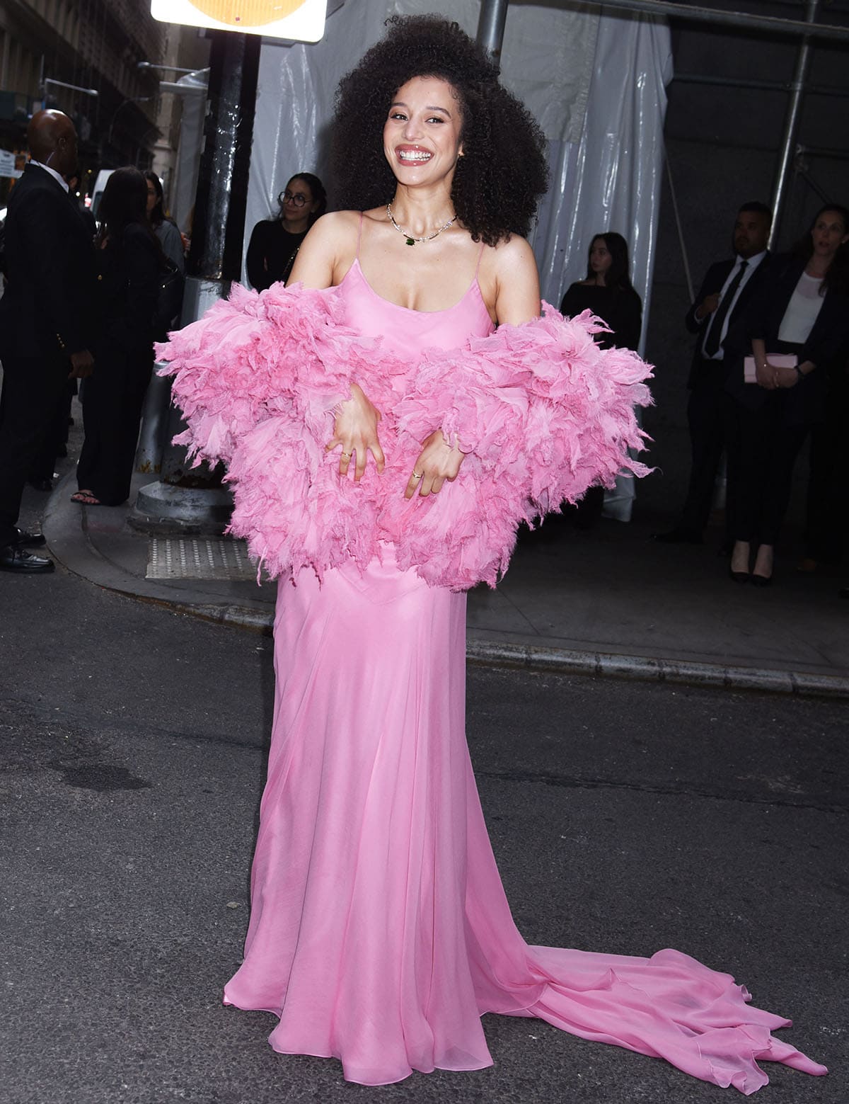 Chase Infiniti pairs her black sandals with a pink Louis Vuitton gown featuring a slip-style dress with an airy, layered, sweeping skirt and a feathery stole
