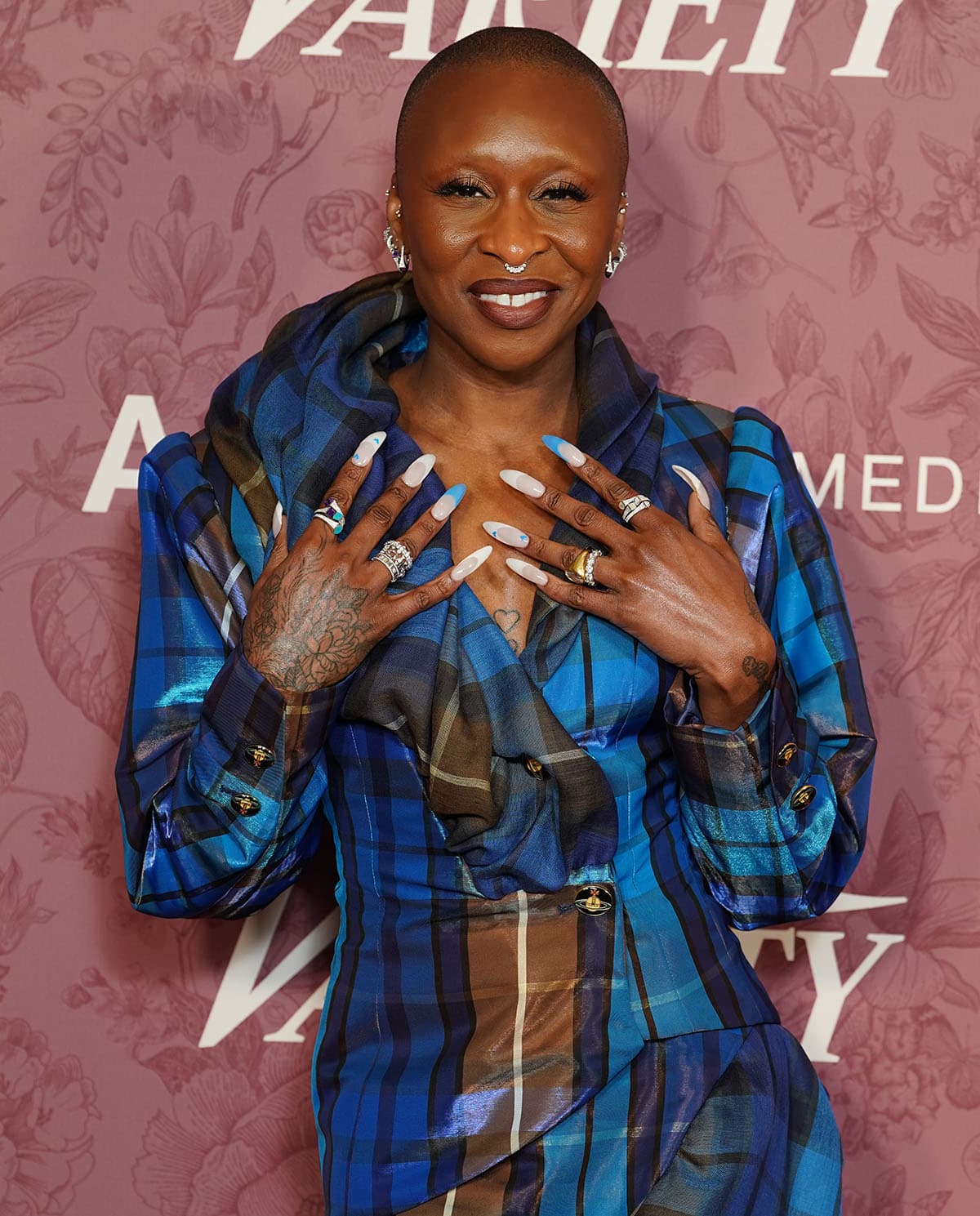 Cynthia Erivo accessorizes with Marli rings, multiple earrings, and nail extensions with French tips in soft pink, white, and blue