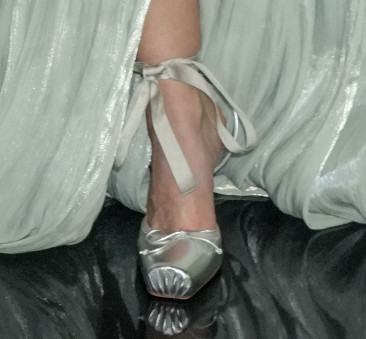 Darla Bundus opts for the charming Christian Louboutin “Cassia” pumps featuring ruched square toes, a delicate bow, and ankle ties