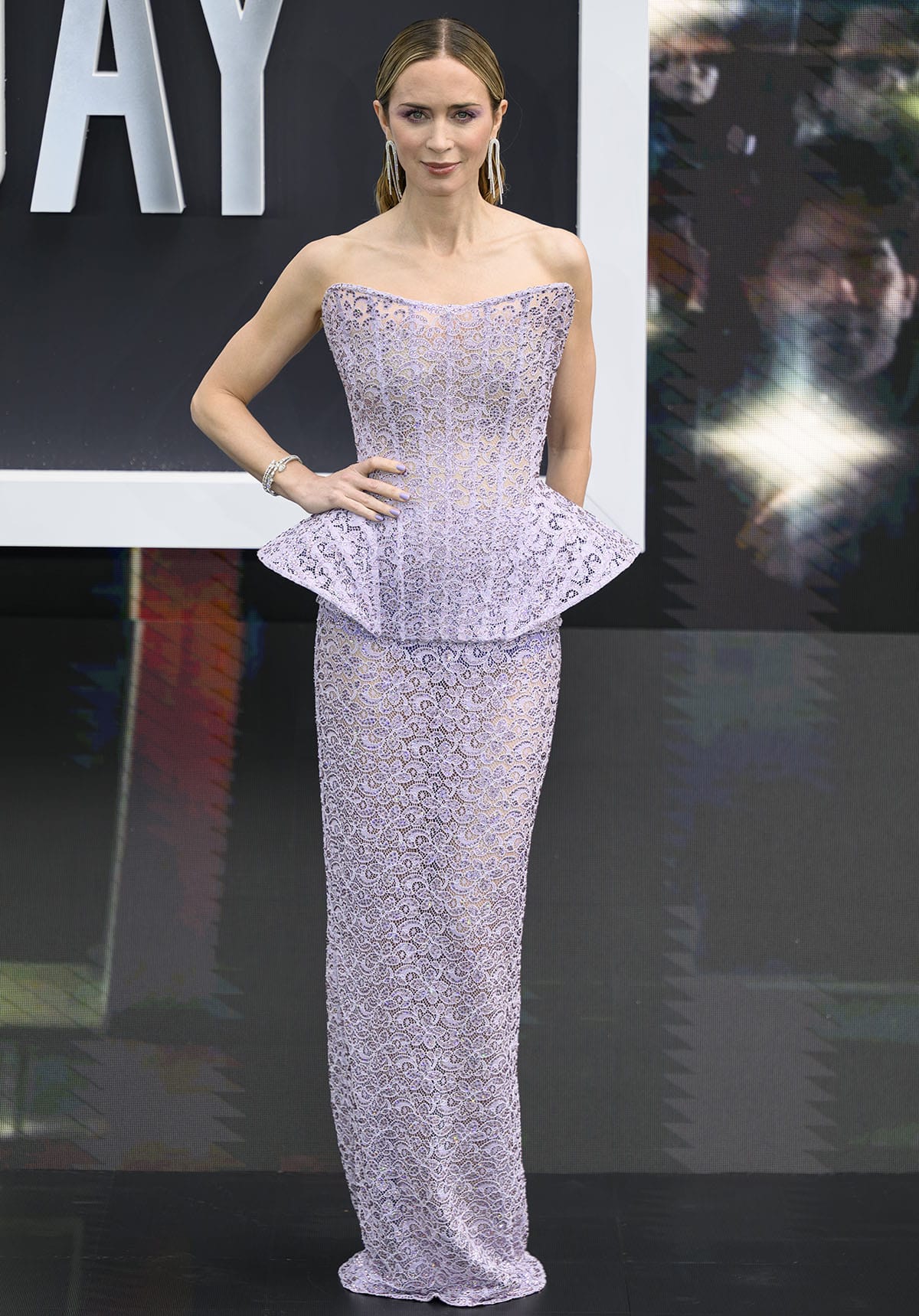 Emily Blunt pairs her lilac mesh pumps with a matching lilac French lace Stella McCartney gown featuring a sharp, sculptural bodice with a peplum and a long column skirt