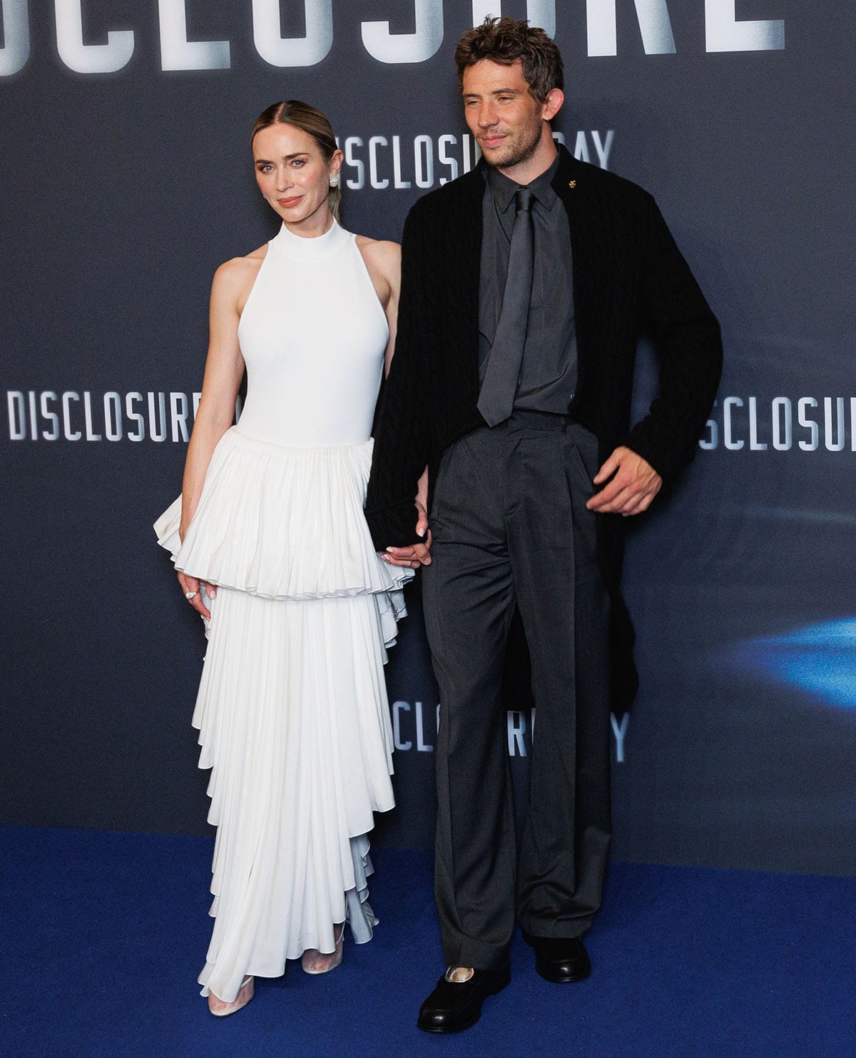 Emily Blunt, with her co-star Josh O'Connor, delivers modern, couture-inspired drama, teaming her mesh pumps with a white sleeveless bodysuit and a tiered, ruffle high-low skirt with a tutu-like upper and a maxi skirt with an inverted triangle silhouette
