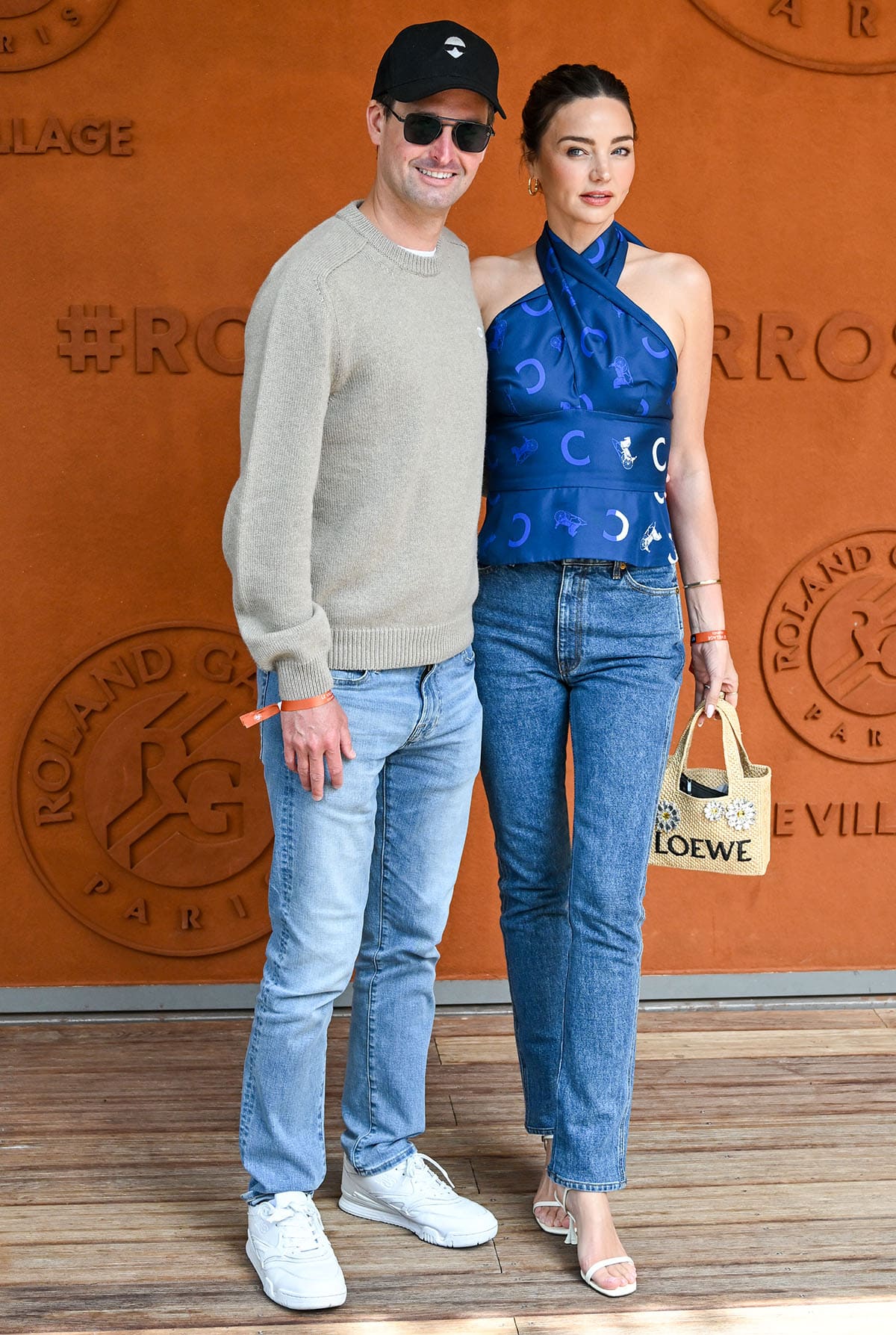 Miranda Kerr, with her husband Evan Spiegel, opts for elevated casuals, pairing her white heels with jeans and a blue Celine halter top