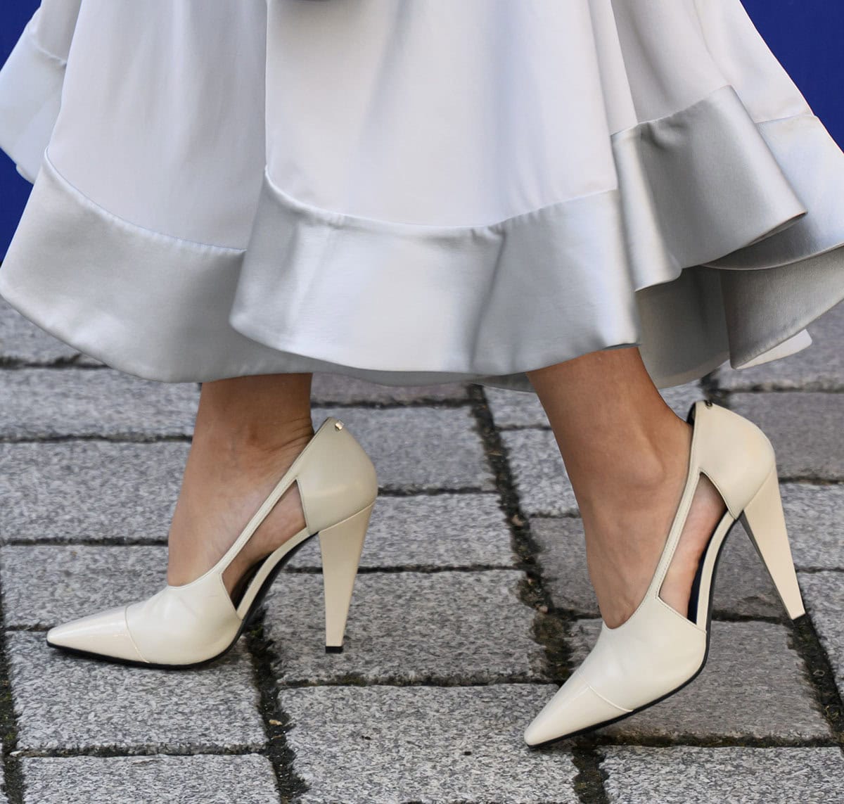 Jenna Coleman steps out in cream leather pumps featuring glossy tonal cap toes, dramatic side cutouts, and sculptural cone heels that lend an architectural finish to her look
