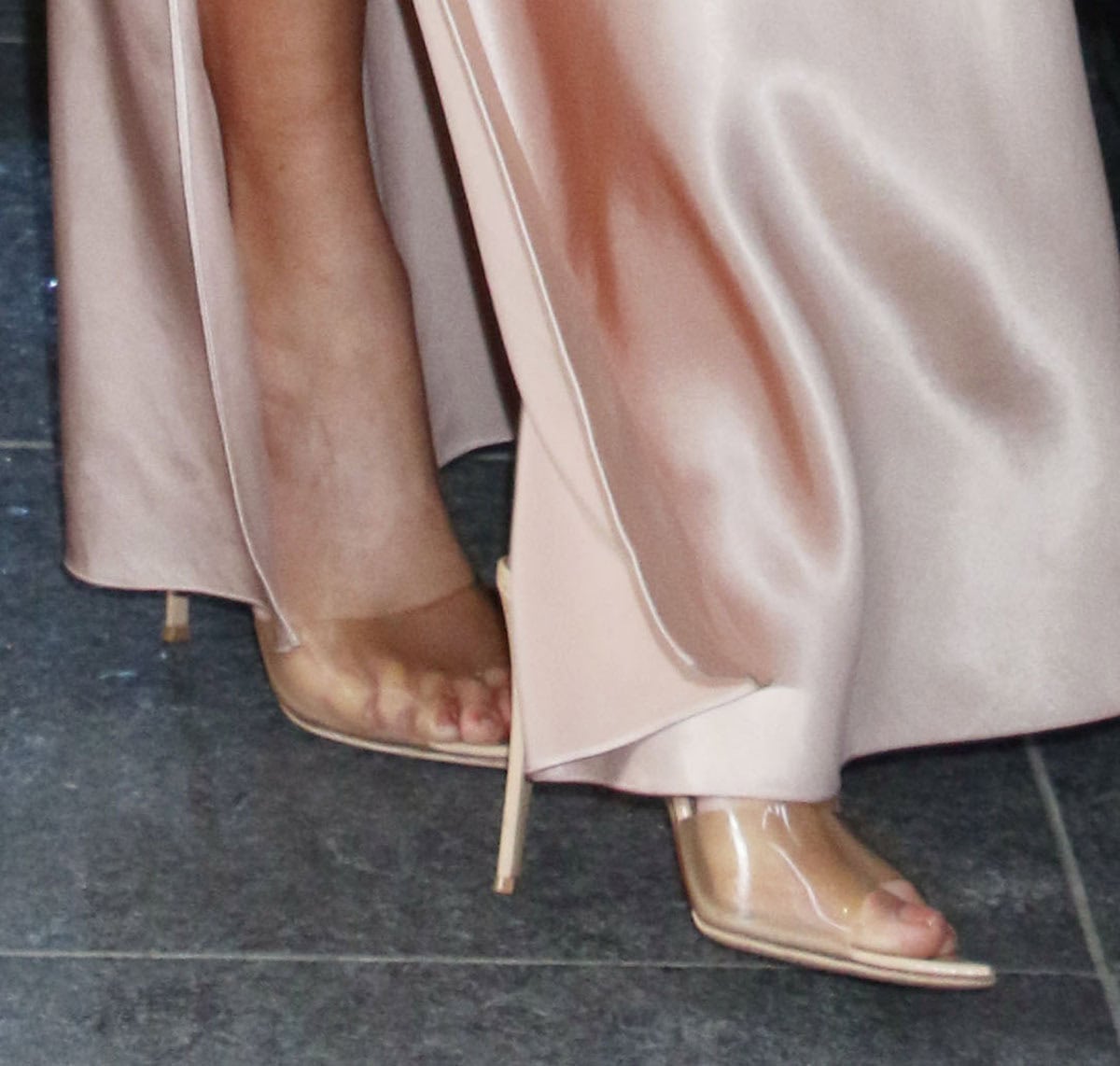 Jennifer Lopez slips into the barely there Gianvito Rossi “Elle” mules with a see-through beige PVC strap, pointed peep toes, and stiletto heels