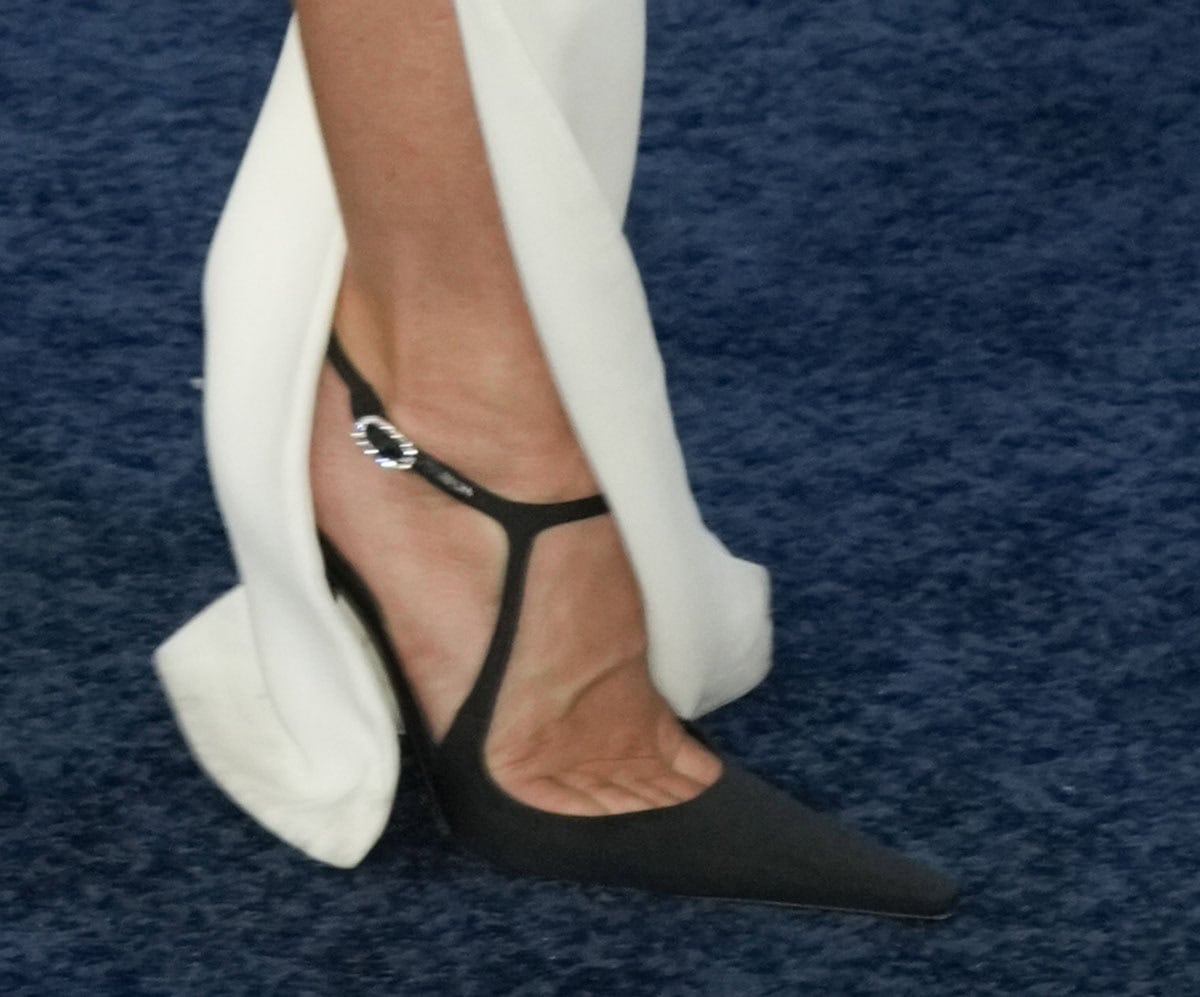 Julianne Hough keeps things clean and sophisticated with black Saint Laurent “Manon” pumps featuring elongated squared toes and an ankle strap with a crystal buckle
