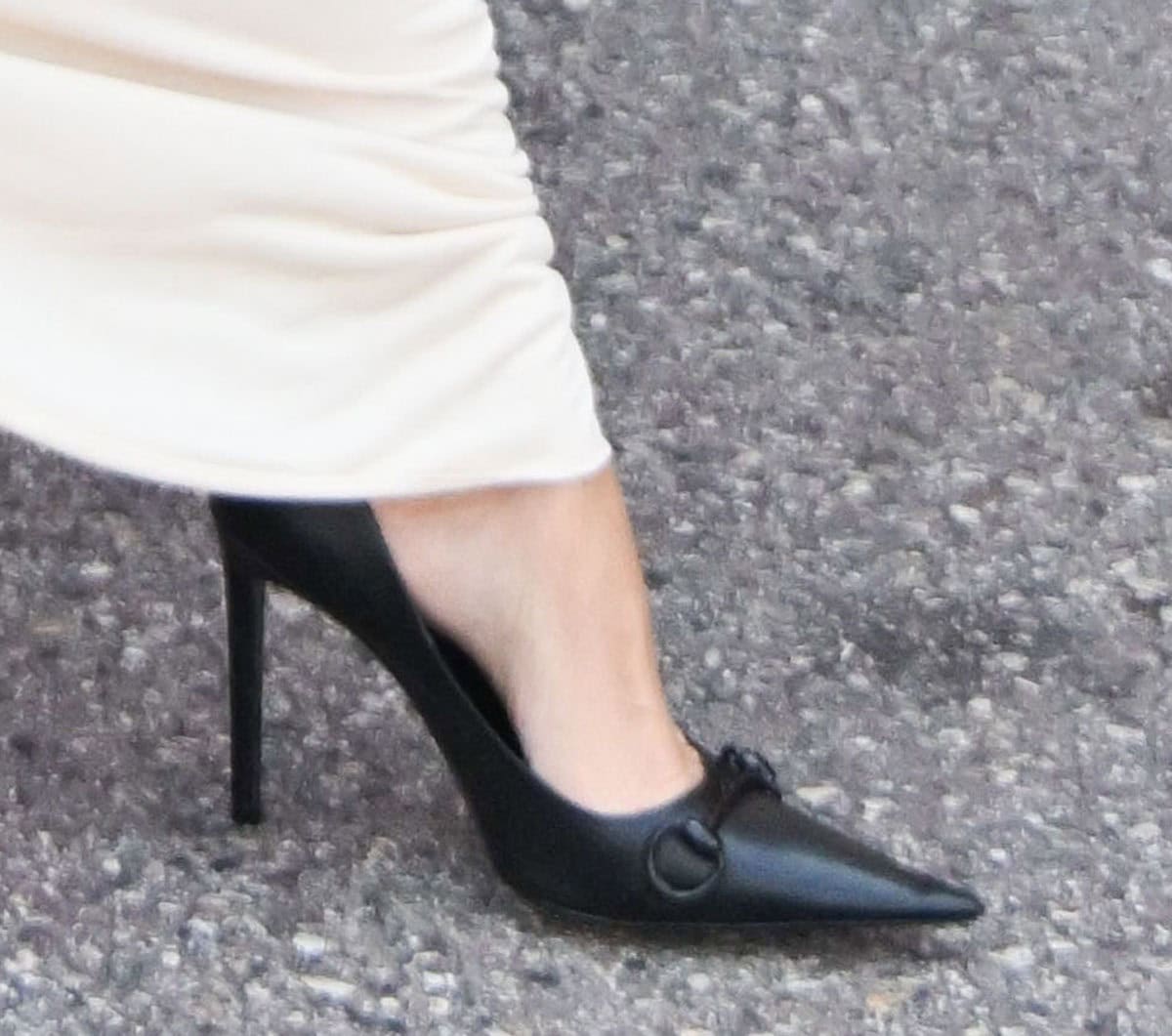 Kim Kardashian slips into a pair of classic black Gucci pumps with sharp, elongated pointed toes, extended horsebit detail, and stiletto heels