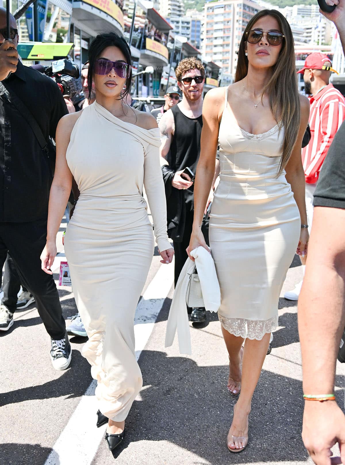 Sisters Kim and Khloé Kardashian match in off-white dresses with striking heels at the Formula 1 Monaco Grand Prix to support Kim's boyfriend, Lewis Hamilton, who is competing for the Scuderia Ferrari F1 Team
