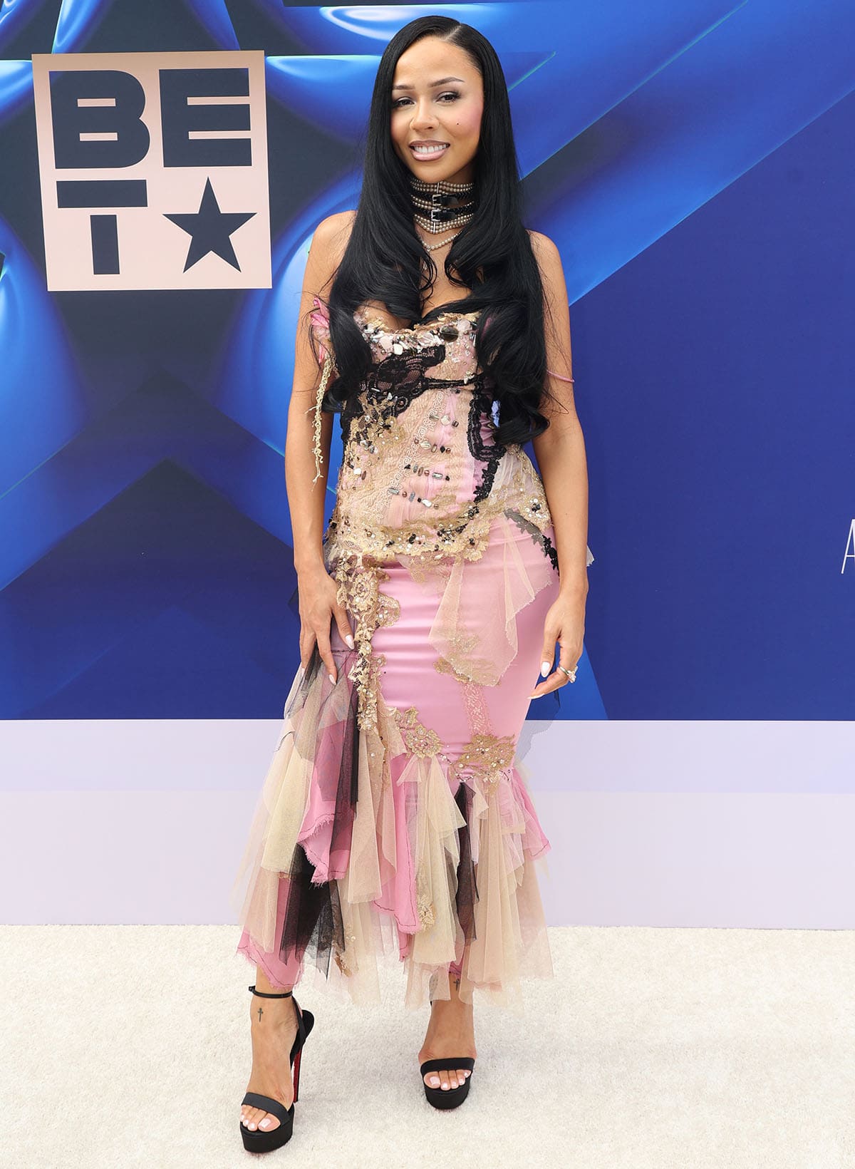 Mariah the Scientist balances the simplicity of her sandals with her elaborate archival Mandalay gown in pink satin with crystals, beads, lace trims, and frayed layers of cream tulle and black mesh