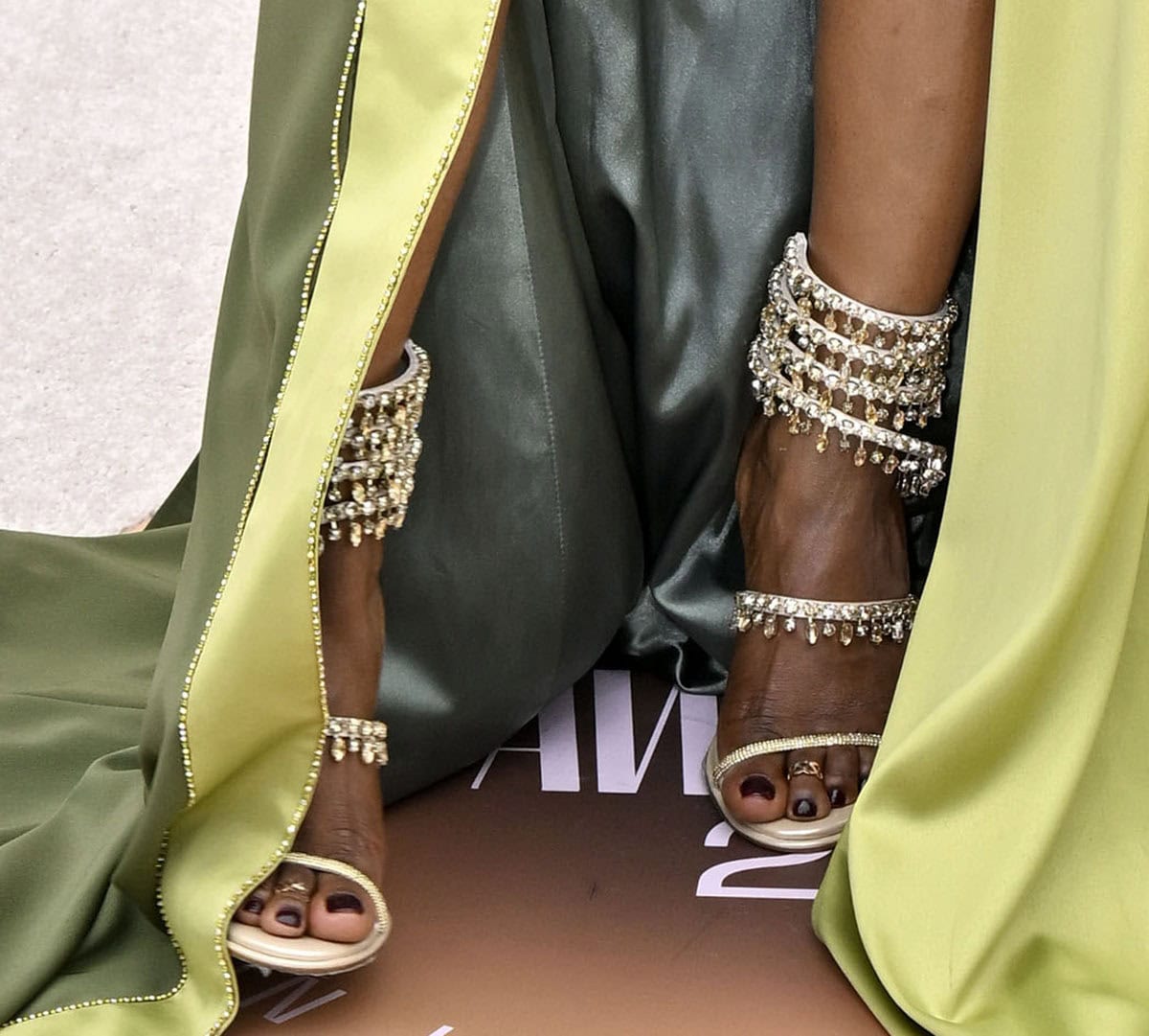 Nadège August draws attention with her René Caovilla “Chandelier” strappy sandals made from satin and leather with slim straps decorated with crystals and hand-stitched crystal drops