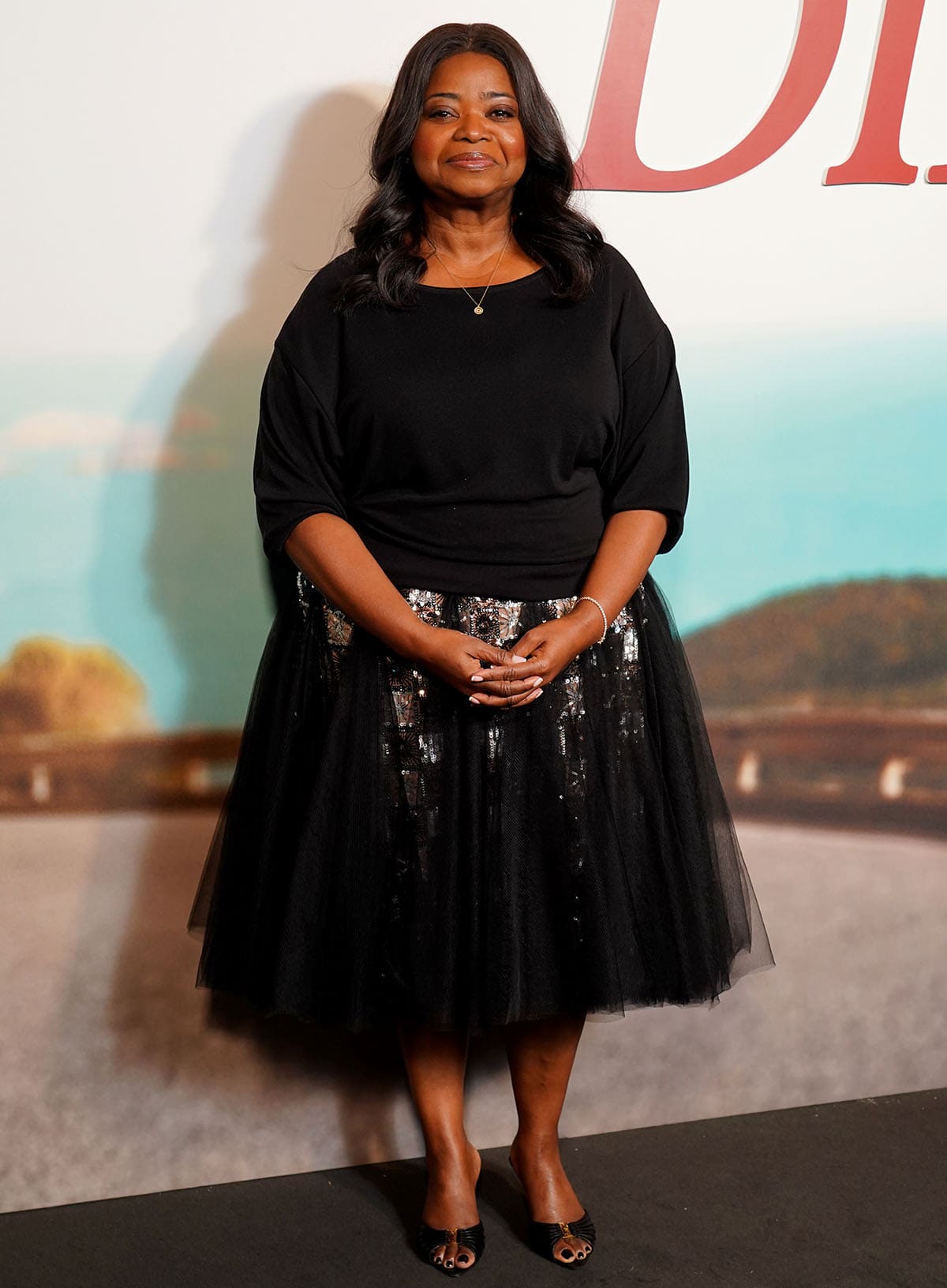 Octavia Spencer pairs her mules with a relaxed black top with quarter-length sleeves and a voluminous tulle skirt with gradient black and silver sequins