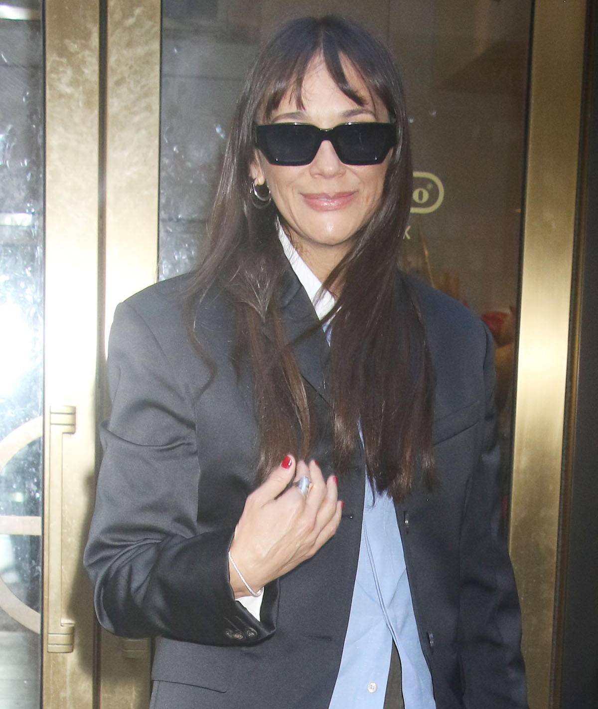 Rashida Jones adds a hint of luxe to her casual tailoring with sunglasses, hoop earrings, a tennis bracelet, and a statement ring