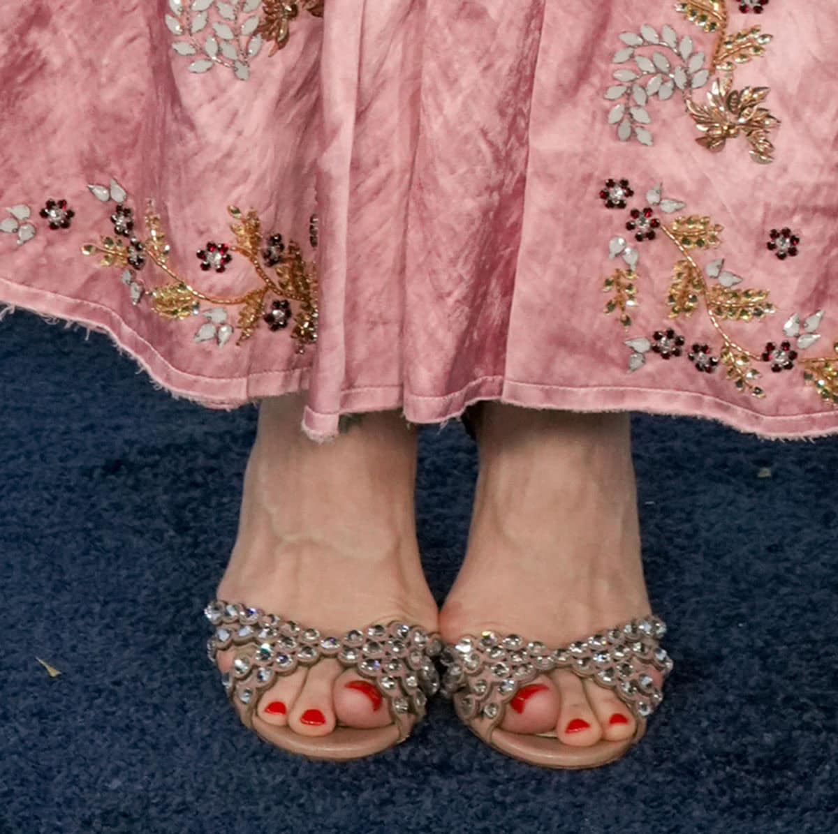 Sarah Paulson showcases her red pedicure in the Aquazzura “Tequila” sandals featuring scalloped straps with clear round crystals