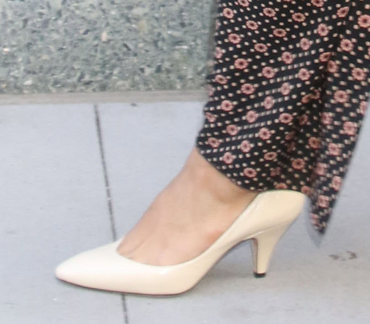Tessa Thompson slips into a pair of off-white crinkled leather pumps by Jude, with low, curved sides, almond toes, and tapered heels