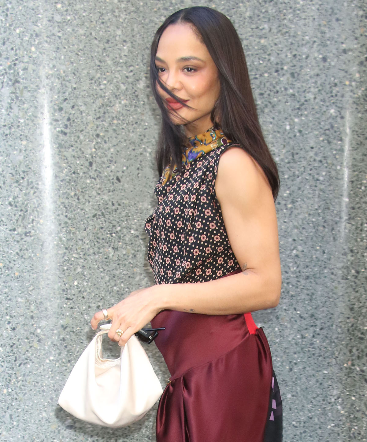 Tessa Thompson adds a minimalist slouchy white bag, sunglasses, earrings, sweet but bold makeup