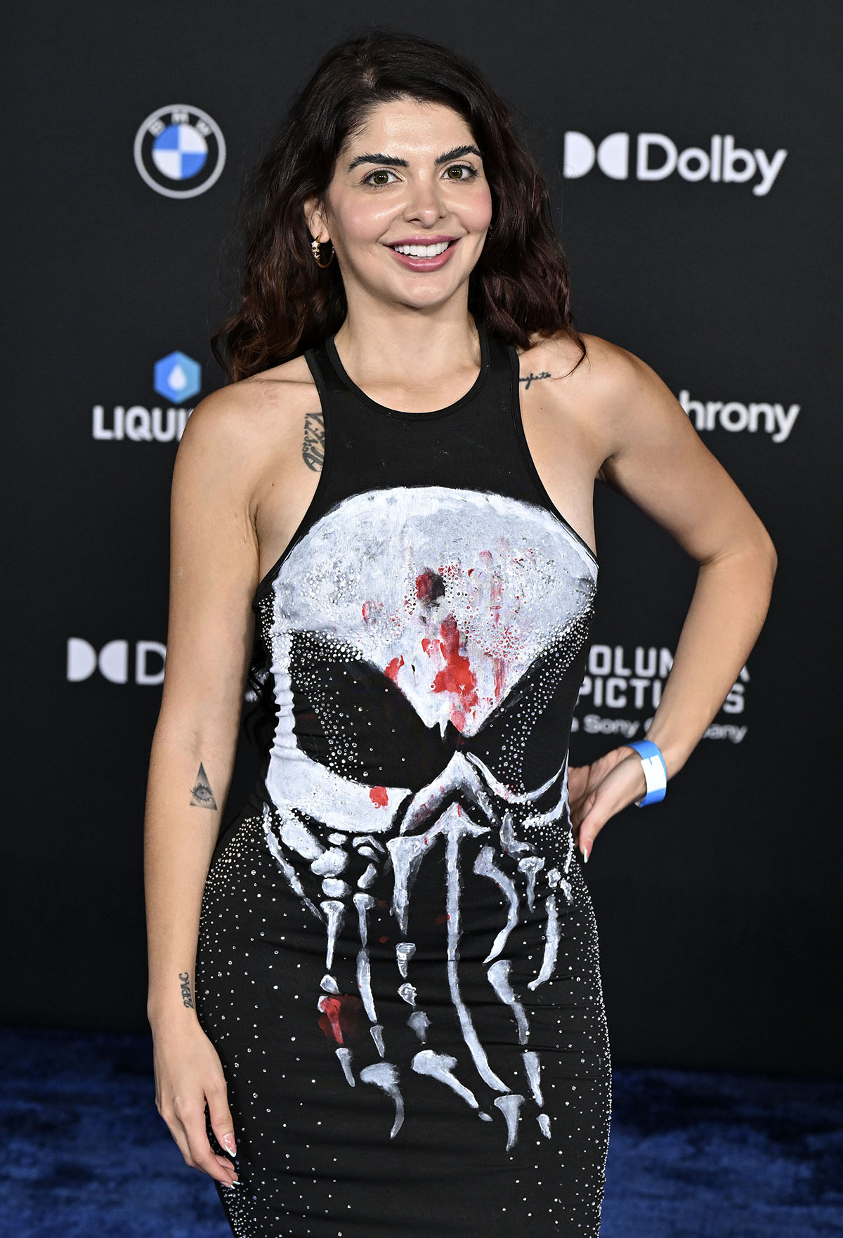 Alyssa Brook Lee pairs her Chanel apple pumps with a black bodycon dress featuring a large white skull graphic splashed with red paint and rhinestone embellishments scattered along the sides
