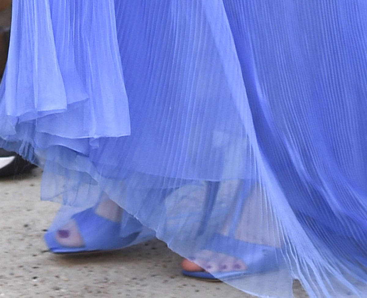 Pregnant Anne Hathaway balances in custom Dior sandals made of cornflower blue satin with T-straps, square open toes, and curved heels