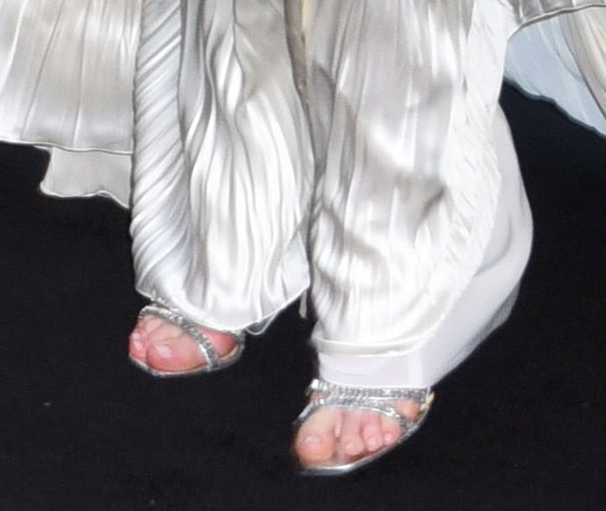Anne Hathaway shimmers in her silver metallic Prada heels featuring rectangular baguette crystals along the front straps