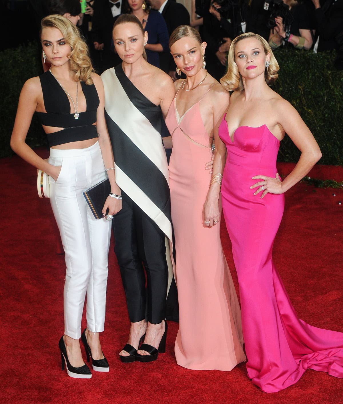 Cara Delevingne, Stella McCartney, Kate Bosworth, and Reese Witherspoon embodied Stella McCartney's sleek take on white-tie glamour at the 2014 Met Gala, pairing sculptural tailoring, soft pink gowns, and statement heels for one of the evening's most cohesive red-carpet moments