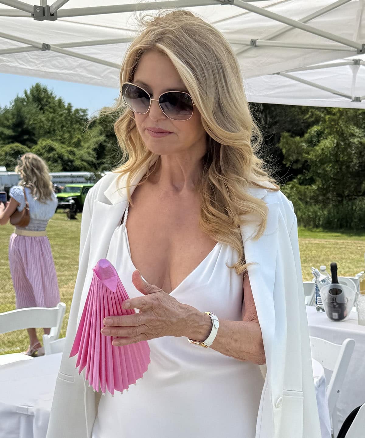 Christie Brinkley completes her elegant summer look with oversized ombre aviators, a white watch, and soft curls