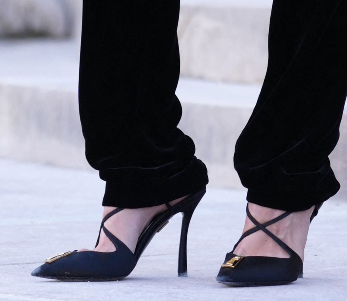 Emma Corrin wears Schiaparelli Keyhole pumps with strappy crisscross straps across the foot, the house's signature Keyhole element, and slightly curved heels