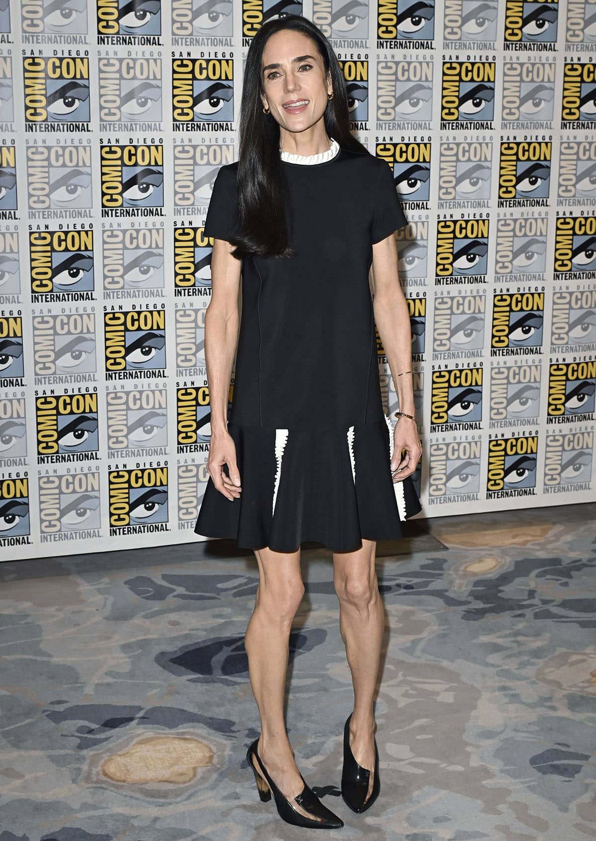 Jennifer Connelly pairs her striking LV cutout pumps with a Louis Vuitton A-line LBD with a flounced hem and white ruffle trims