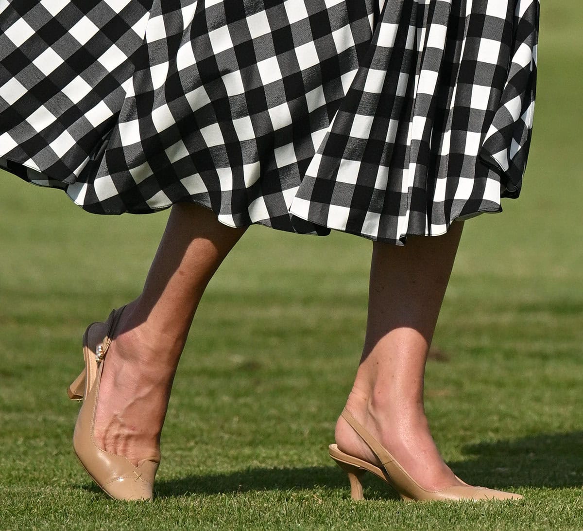Kate Middleton opts for the Camilla Elphick “Lucia” pumps in tan leather with nude patent pointed cap toes, a slingback strap with a pearl buckle, and angular kitten heels