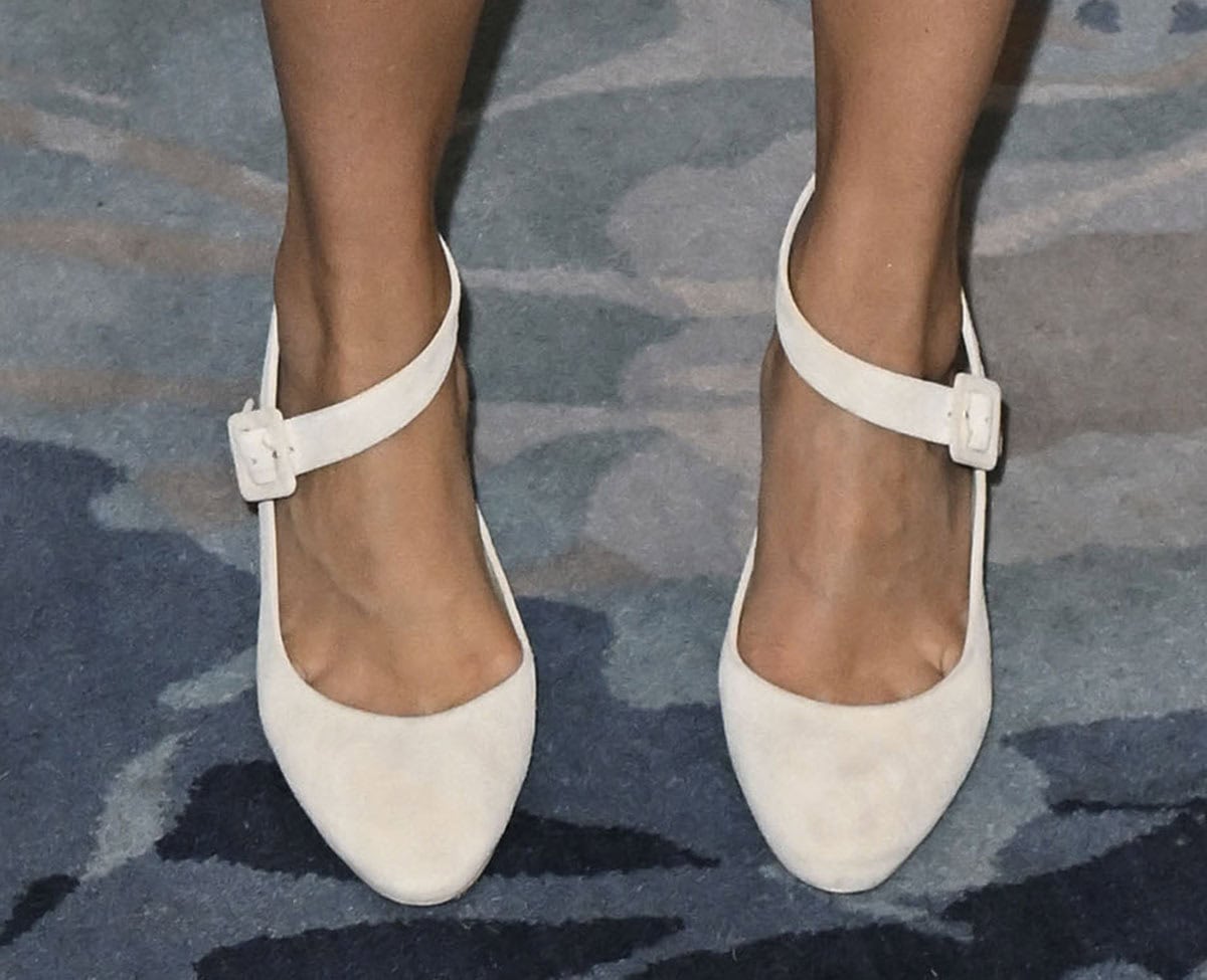 Lauren Cohan elevates her rather relaxed outfit with mushroom gray suede Larroudé “Deena” pumps featuring an asymmetrical strap that crosses diagonally over the foot and fastens with a tonal square buckle