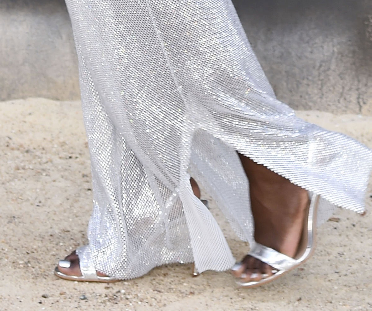 Lupita Nyong'o shines in the barely there Aquazzura “So Nude” slingback sandals made of mirrored silver leather