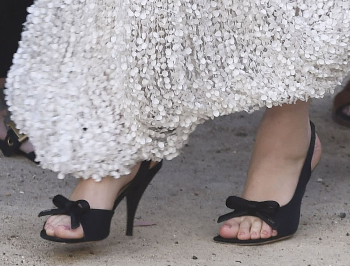 Mia Goth opts for the feminine Dior “Bow” sandals featuring the house's signature bow, D-shaped soles, and slingback straps