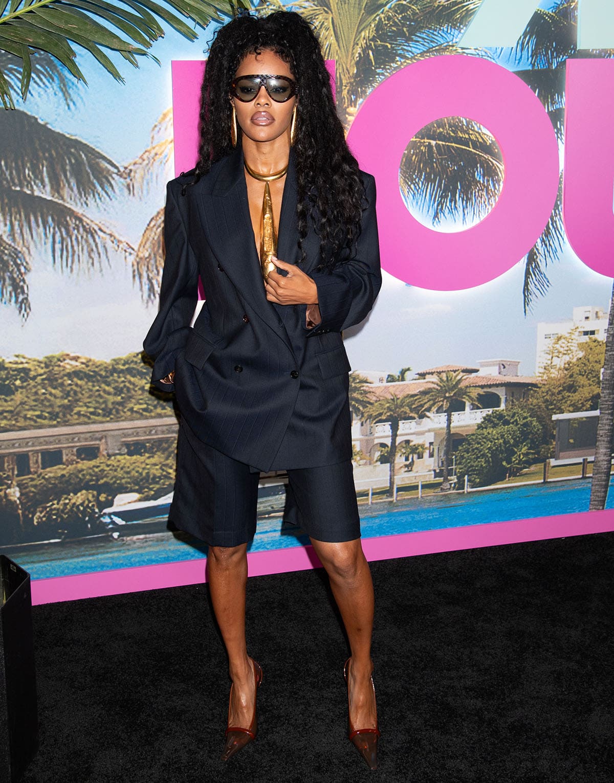 Teyana Taylor pairs her semi-transparent TPU pumps with an oversized navy blazer and matching Bermuda shorts