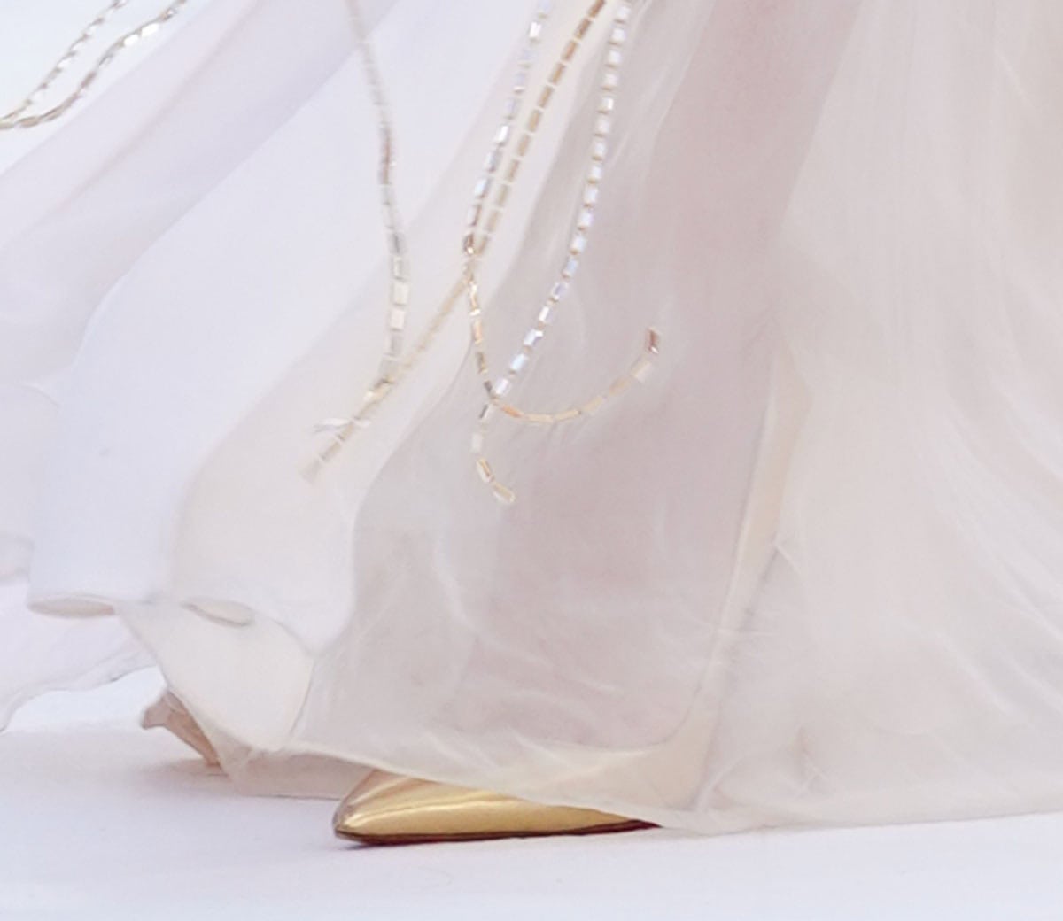 A glimpse beneath Zendaya's crystal-embroidered Tamara Ralph gown reveals metallic gold pointed-toe pumps—likely Christian Louboutin's signature So Kate style—at the Spider-Man: Brand New Day London premiere