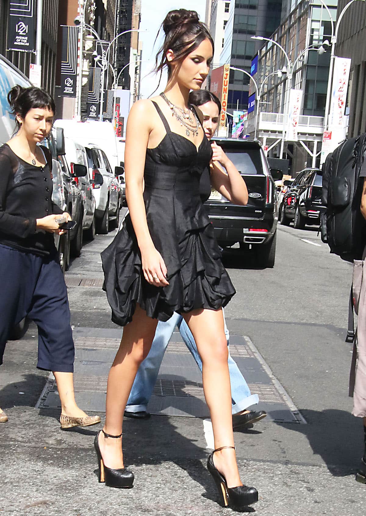 Ashtin Earle pairs her chunky platform pumps with a chic LBD featuring a corset bodice and a voluminous parachute-style mini skirt with dramatic ruffles
