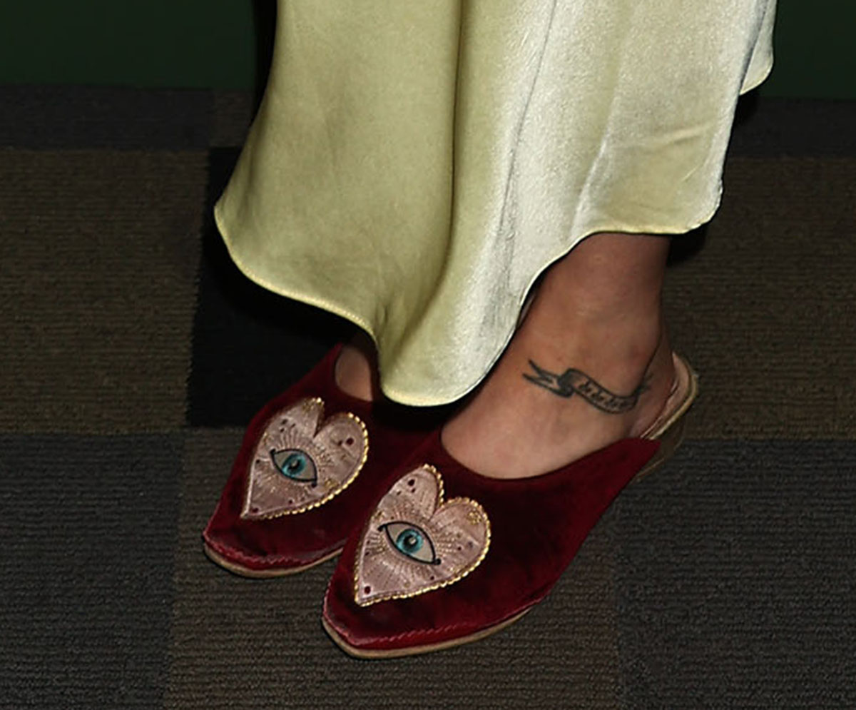 Emily Meade adds a whimsical element to her retro lingerie look with the Butrich “Euridice” mules, featuring red velvet uppers embroidered with oversized satin hearts across the vamps, finished with sunburst and eye motifs