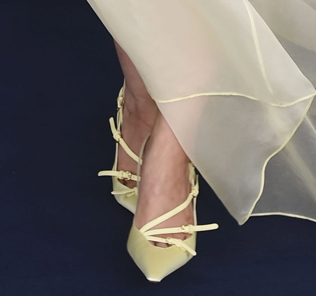 Joey King opts for the strappy Miu Miu pumps with elongated squared toes, slim buckled straps, a slingback strap, and high heels