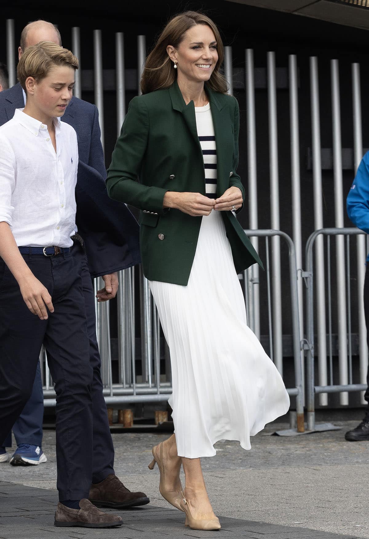 Kate Middleton pairs her nude heels with a breezy pleated white midi skirt by Christopher Kane, a nautical striped vest top by La Ligne, and a forest-green Ralph Lauren blazer